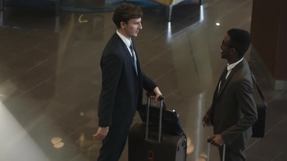 Diverse Colleagues Greeting Each Other in Hotel Lobby alt