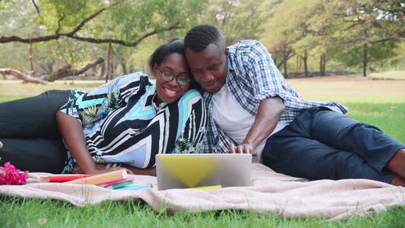 Romantic black couple having picnic in the park, celebrating anniversary, dating