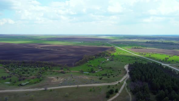 A Bird'seye View of the Road Between the Forest and Green Fields