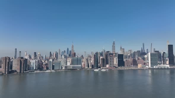 A high angle, aerial view of the Eastside of Manhattan from over Long Island City, NY on a sunny day alt