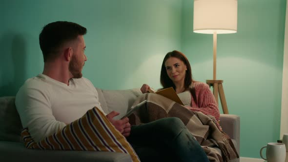 Woman and Man Are Sitting On Sofa and Talking