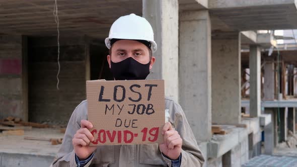 Engineer in Mask and Hardhat Stands with Placard Lost My Job Due Covid-19
