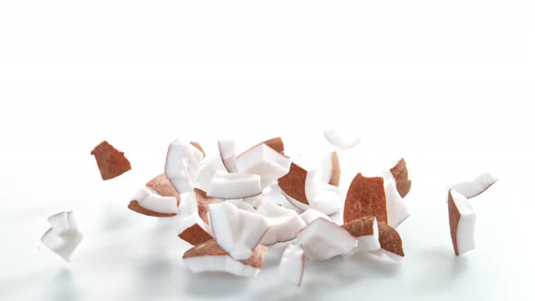 Super Slow Motion Shot of Falling and Breaking Fresh Coconut on White Background at 1000Fps alt