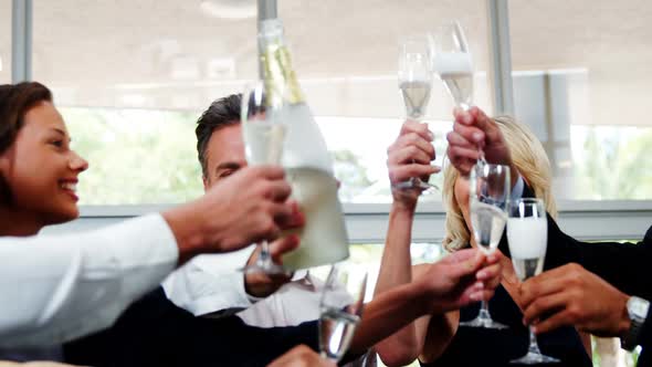 Group of smiling friends toasting champagne glass alt