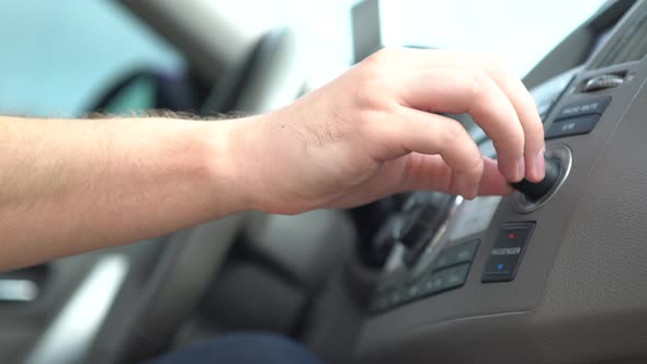 Driver Adjusting a Control Knob in His Car alt