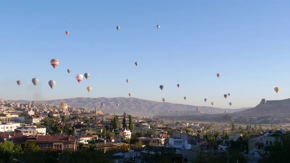 Colorful Hot Air Balloons flying over Goreme town in Cappadocia, Turkey alt