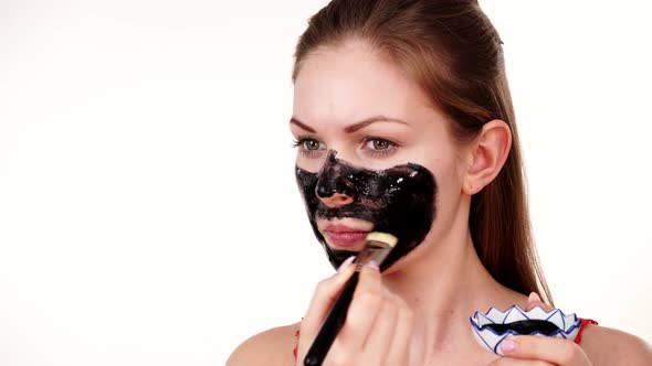 Girl Applying Carbo Mask to Face