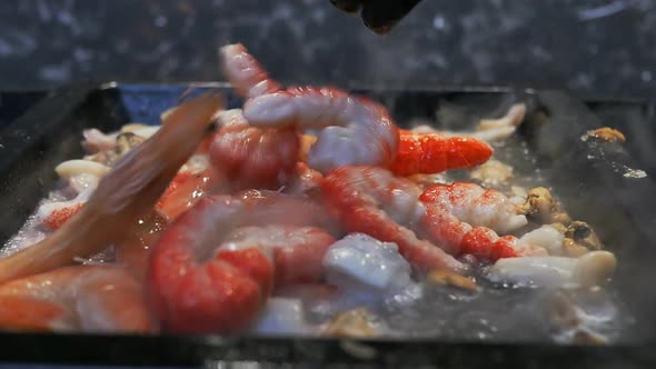 the Chef Dumps the Shrimp Onto a Baking Sheet in Which the Malus Oysters and Squid are Boiling