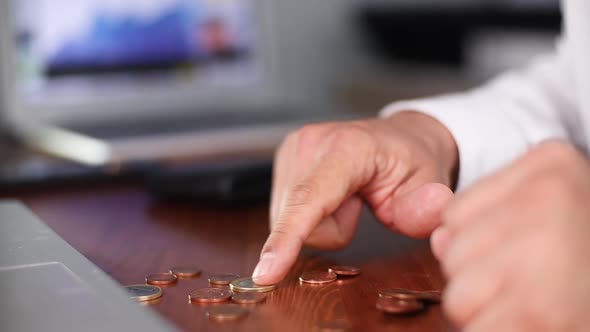 Businessman Counting Coins in the Office