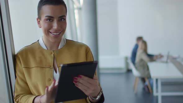 Young short hair business woman standing in the office and using digital tablet