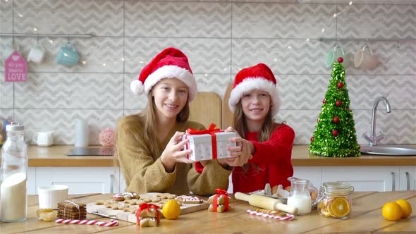 Little Girls Making Christmas Gingerbread House in Kitchen alt