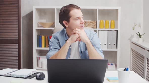 Workplace of freelance worker at home office. Young man works using computer. alt