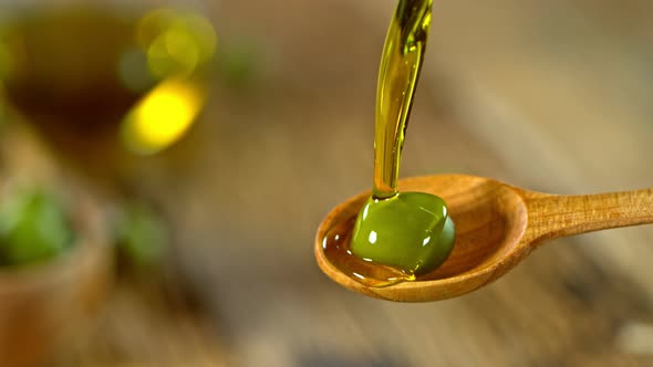 Super Slow Motion Shot of Pouring Fresh Olive Oil on Olive at 1000 Fps. alt