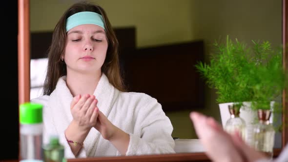 4k Happy attractive young woman applying a tonic at her pretty face