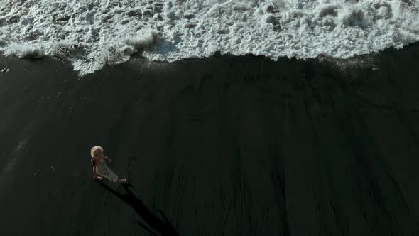 Top View of a Girl Strolling Along a Black Volcanic Beach, Tenerife, Canary Islands, Spain