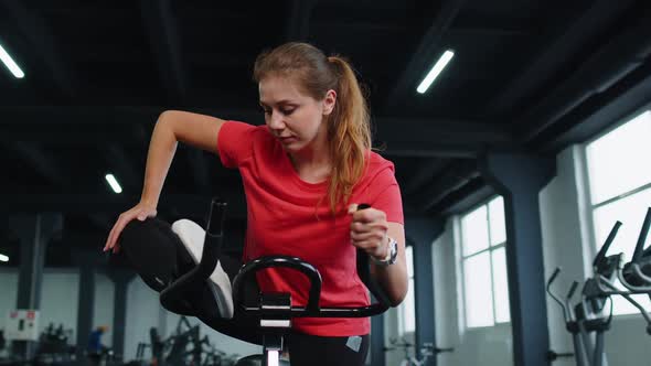 Athletic Women Group Training Stretching on Spin Stationary Bike Routine in Gym Indoors alt