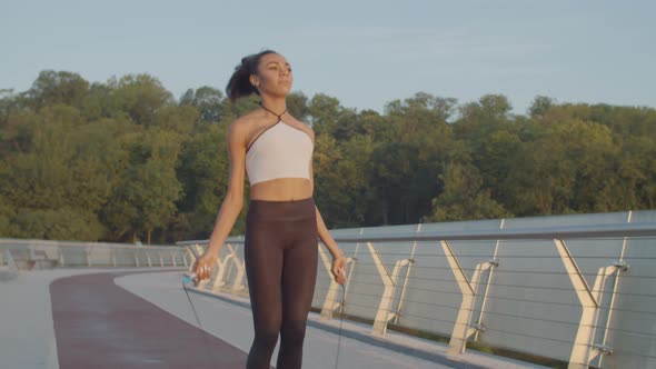 Black Woman Exercising with Skipping Rope Outdoors alt