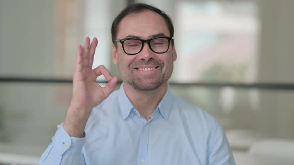 Portrait of Positive Middle Aged Man Showing OK Sign alt