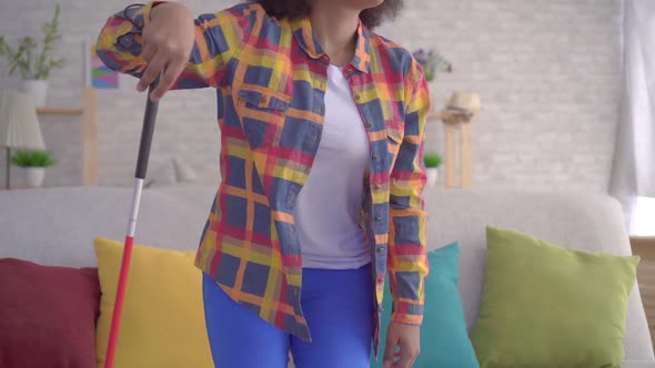 African Woman with an Afro Hairstyle Visually Impaired in Glasses with a Cane in His Hands alt