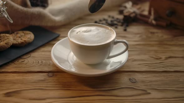 Woman Hand Putting Out Sugar Cube Into Cup of Coffee alt