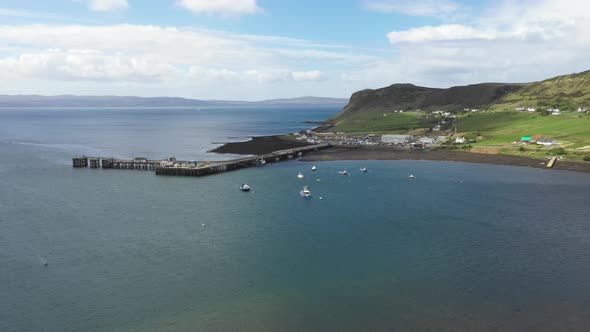 Aerial drone view of little harbour on the coast of Scotland on a sunny day