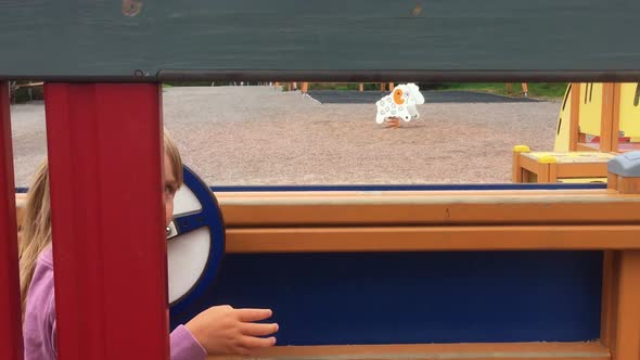 Cute girl playing and talking at kindergarten pretending to drive the bus and talking to customers alt