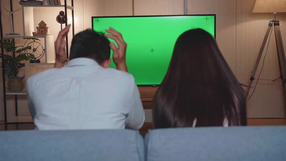 Asian Couple Is Frustrated About The Loss Of The Team In Game, Watching Tv With Green Screen alt