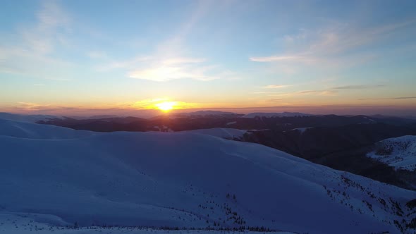 Flight Over the Snowy Mountains Illuminated By the Evening Sun alt