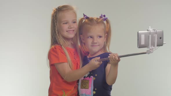 Two little girls taking selfies alt