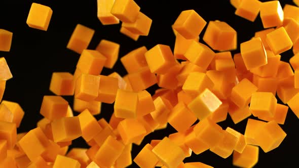 Super Slow Motion Shot of Flying Cheddar Cheese Cubes on Black Background at 1000 Fps alt