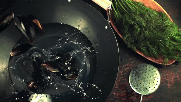 Super Slow Motion Mussels Fall Into the Pan for Cooking with Splashes alt