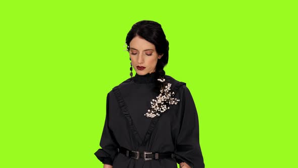 Portrait of Young Stylish Woman Singing Sad Song on Green Background
