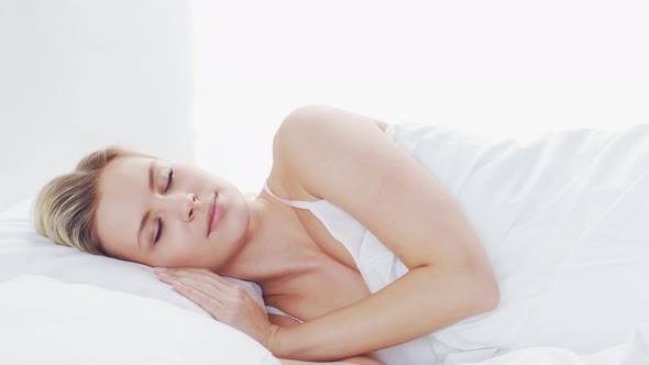 Young woman lying in the bed. Beautiful blond sleeping girl. Morning in the bedroom. alt