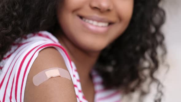 Vaccinated African American Woman Showing Arm with Medical Plaster Patch Plaster On Shoulder Black alt