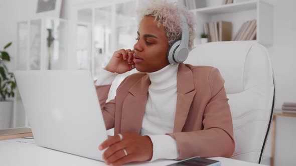 African American Woman Takes Pleasure From Music in Wireless Headphones alt