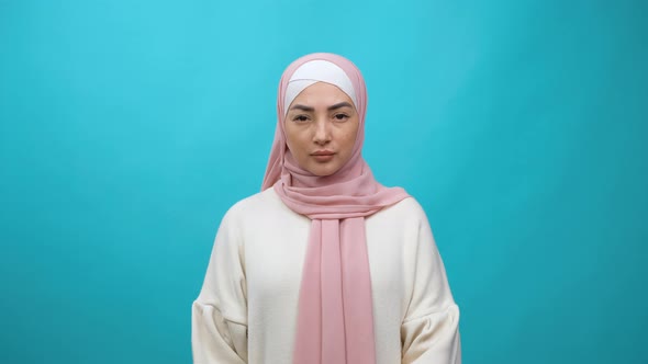 Portrait of Serious Young Muslim Woman in Hijab Standing Calm Emotionless Looking at Camera with