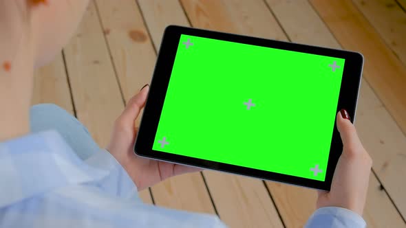 Chroma Key Concept - Woman Looking at Tablet Computer with Blank Green Screen