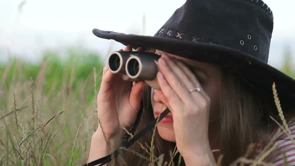 Beautiful Young Girl Looking Through Binoculars On Blue Sky Background. alt