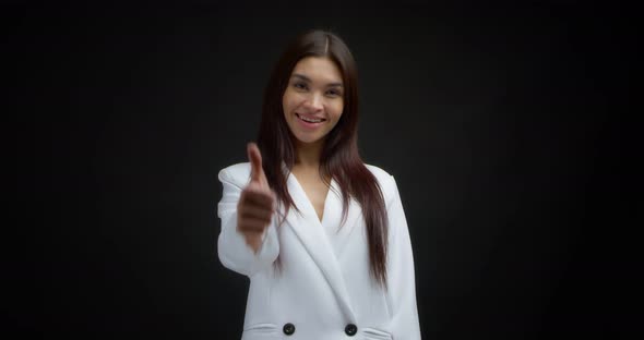 Positive Woman Smiles at the Camera and Gives a Thumbs Up
