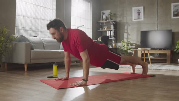 Young Man is Doing Pushups Exercises at Home Keeping Himself During Lockdown alt