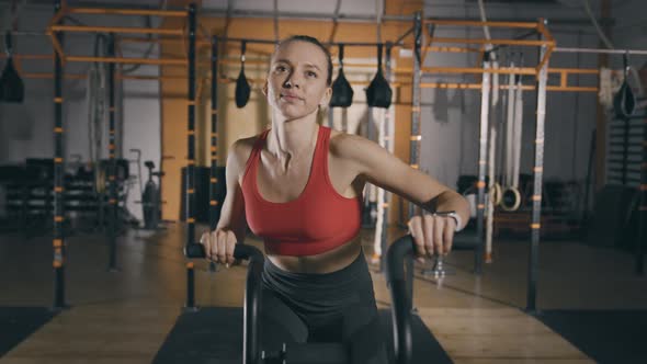 Young Woman Trains on Exercise Bike alt