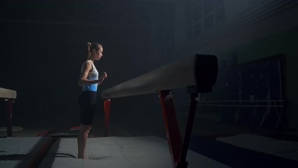 Sporty Teenager Girl is Training with Balance Beam in Dark Gymnastic Hall Discipline of Artistic alt