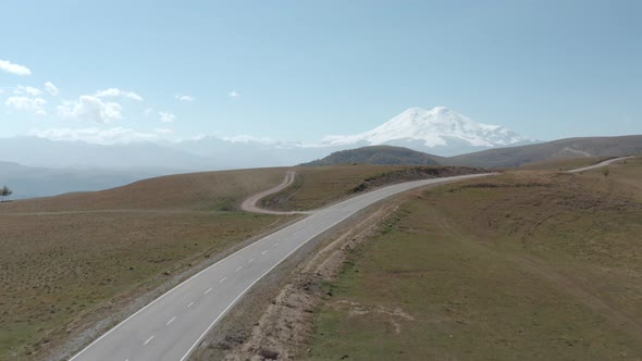 Hills and Plains in Mountain Valley Dzhily Su Elbrus. Winding Empty Asphalt Road in Highlands From alt
