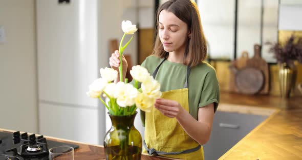 Woman Decorates Home Interior with a Bouquet of Fresh Flowers alt