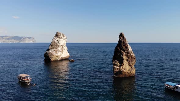 Aerial View of Tourist Boats in the Sea Bay Next To Individual Rocks and High Rocky Coast alt