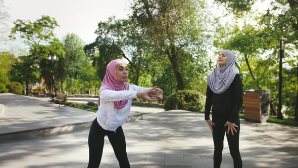 Two Darkskinned Muslim Ladies in Sportswear and Colorful Hijabs alt