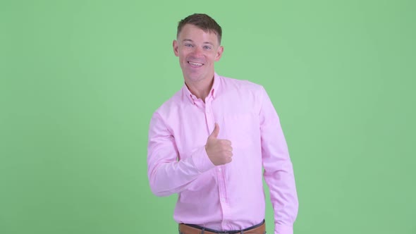 Portrait of Happy Businessman Giving Thumbs Up alt