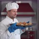 Male Cook Smelling Fresh Croissants Standing in Bakery Kitchen - VideoHive Item for Sale