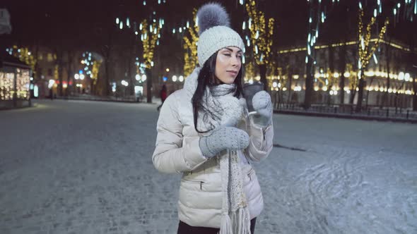 Lady Drinking Coffee and Admiring Christmas Illuminations. alt
