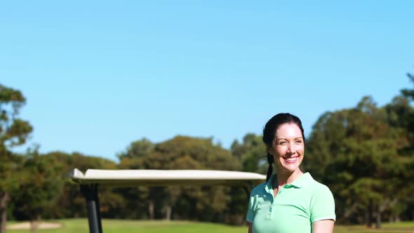 Happy female golfer playing golf alt